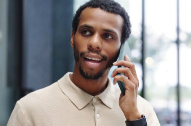 İşadamı ofisinde cep telefonuyla konuşuyor.