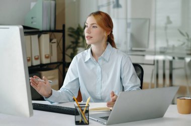 Meslektaşım modern ofiste masa başında proje detaylarını tartışıyor. Arka planda çeşitli ofis malzemeleri ve ekipmanlar görülüyor. Bu da profesyonel bir çalışma ortamı olduğunu gösteriyor.