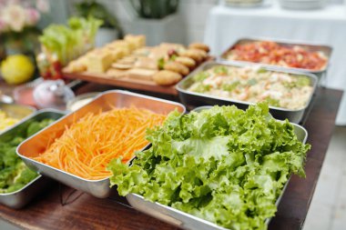 Tepsilerde süslenmiş salatalar da dahil olmak üzere çeşitli yemekler bir etkinlikte sergileniyor