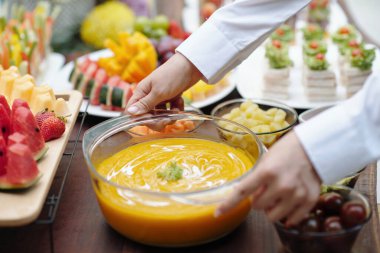 Mikro yeşilliklerle süslenmiş güzel kaplanmış gurme tabağı tutan sunucuya yakın çekim