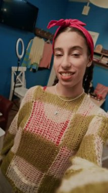 Yatakhane odasından sosyal medyada canlı yayın yaparken kamerada konuşan esmer gen Z 'nin dikey POV' u