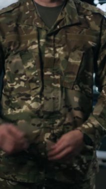 Beyaz askerin dikey portresi. Kumanda merkezinde kameraya poz veriyor.