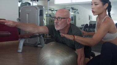 Orta boy, orta boylu, beyaz tenli bir sporcunun orta sahada bayan Asyalı koçla antrenman yaparken spor yaparken.