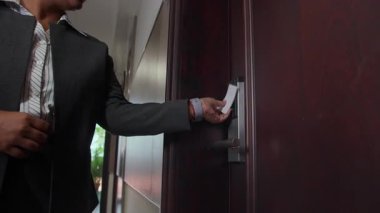 Bayan resepsiyonistin, tatil sırasında otele giriş yapmak için anahtar kartla kapı kapı dolaşması düşük açılı bir bakış açısı.