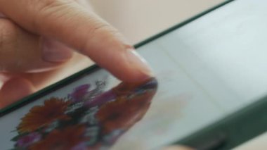 Tanımlanamayan kadın kullanıcısının cep telefonunda internette gezinirken makro görüntüsü.