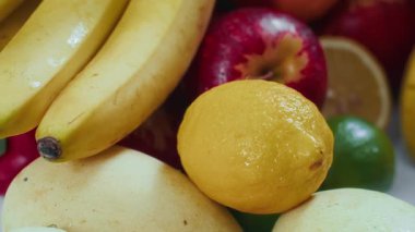 İştah açıcı muzlar, elmalar, mango, ananas ve kapalı bir masa.