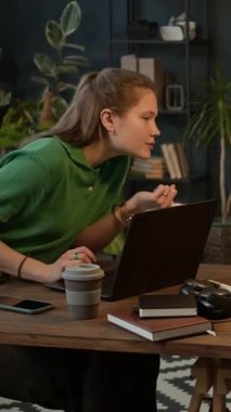 Kafkas kökenli Z jenerasyonunun kadın çalışanı kablosuz bilgisayarda çalışırken ofis masasındaki görevleri tartışırken dikey çekim.