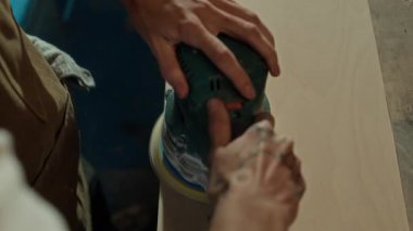 Çalışanların atölyedeki tahtaları cilalamak için parlatma makinesi kullandıkları yüksek açılı bir görüntü.