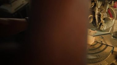 Yüksek açılı çekimde işçi torna ile kontrol ediyor ve fabrikada tahta kesiyor.