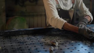 Kadın işçinin atölyede metal detaylarıyla çalışırken orta boy fotoğrafı.