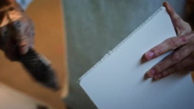 Genç marangozun ahşap tahtayı törpülediği yakın çekim.