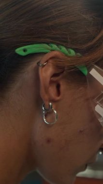 Çalıştığı atölyede cilalama makinesiyle çalışan genç bir kadının dikey çekimi.