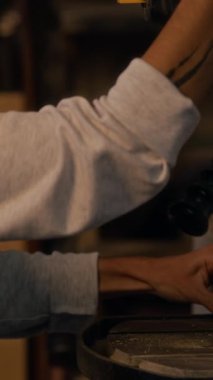 Çalışanların atölyede matkapla tahtaya delik açtıkları dikey çekim.