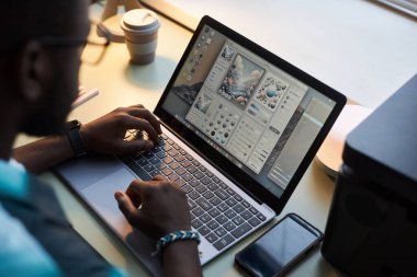 Ofiste dizüstü bilgisayarla çalışan grafik tasarımcısının yüksek açılı görünümü