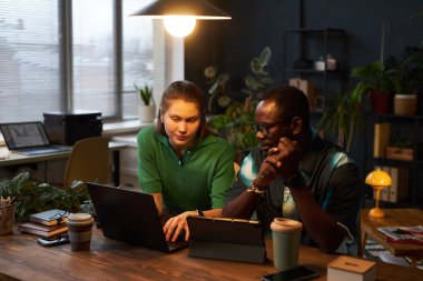 Genç meslektaşlar, eko ofisindeki takım çalışması için online proje üzerinde çalışırken aygıtlar kullanıyorlar.