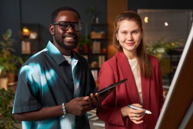 Çevre ofisindeki ekip çalışması ve planlama üzerine notlar yazan genç iş arkadaşlarının portresi