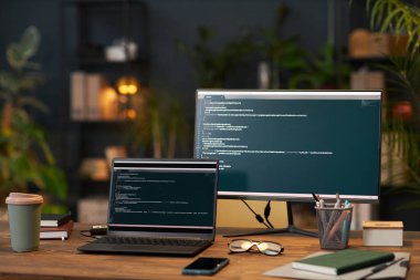 Ofisteki programcının işyerindeki bilgisayar monitörlerindeki kodlama ekranları