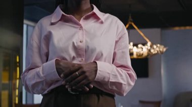 Resmi giysili genç Afrikalı Amerikalı iş kadınının portresi modern ofiste kameraya poz veriyor.