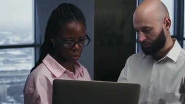 Ofisteki iş yerinde dizüstü bilgisayar kullanan çeşitli resmi olan genç çalışanların orta boy fotoğrafları.