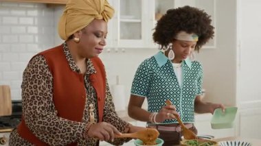 Ev mutfağında öğle yemeği servisi yaparken anne ve babanın iletişim kurduğu orta boy bir fotoğraf.