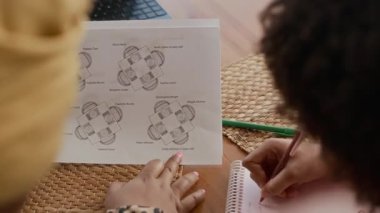 Evde akşam yemeği için iki kişilik bir oturma düzeninin omuzlarının üstünden.