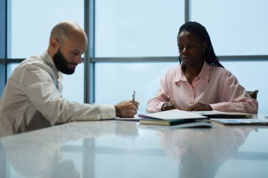 Yönetim kurulundaki masada otururken iş arkadaşları birlikte çalışmayı planlıyor ve tartışıyorlar.