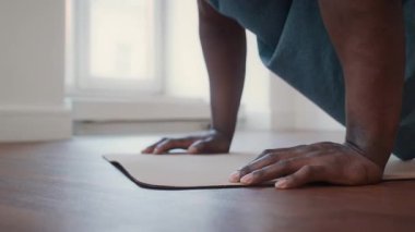 Spor salonundaki antrenman sırasında siyah bir adamın spor minderinde şınav çekişini yakından çek.