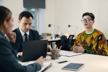 Genç adam ofiste iş adamlarıyla görüşüyor.