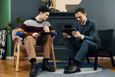 İş adamı, iş arkadaşıyla iş yerinde görüşürken dijital tablet üzerindeki sözleşmeyi inceliyor.