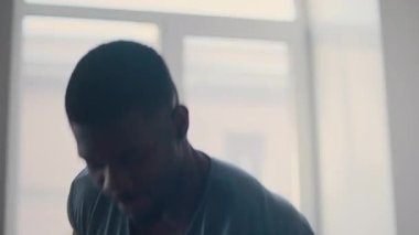 Kas yığını Afrikalı Amerikalı adam ev spor salonunda yoğun idman sırasında kettlebell salıncakları yapıyor.