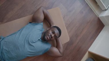 Spor salonunda antrenman yaparken alnından ter silerken yorgun siyah adamın kamera kayan görüntüsü.