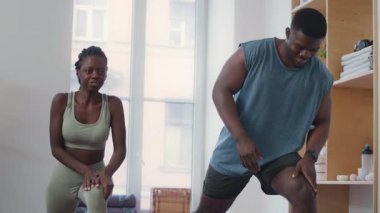 Genç Afrikalı Amerikalı erkek ve kadının spor giyim kuşamında spor salonunda spor yaparken çekilen çekimler.