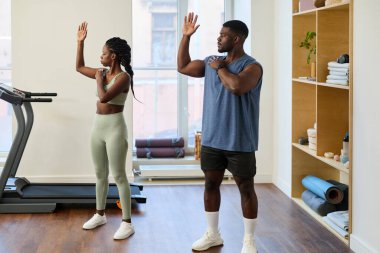 Afrika kökenli Amerikalı erkek ve kadın spor salonunda spor yapmaya hazırlanıyorlar.