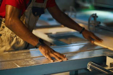 Atölyedeki torna tezgahında ahşap tabela hazırlayan işçilere yakın çekim