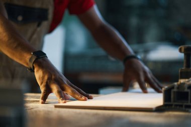 Torna tezgahında duran ve işaret için tahta yapan işçilere yakın plan.