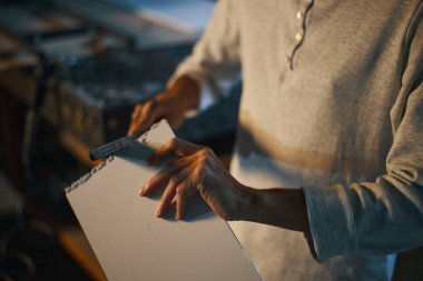 Atölyede tahtayı cilalamak için dosya kullanan işçilerin yakın plan görüntüleri