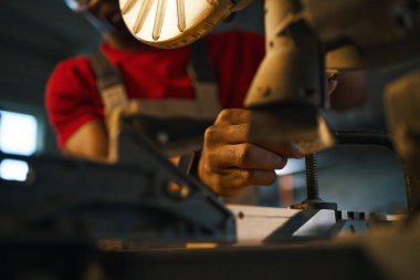 Torna tezgahını kontrol eden işçilere yakın plan.