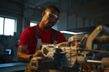 Torna fabrikasındaki işi kontrol eden Afrikalı Amerikalı manuel işçi.