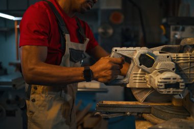 Afrikalı Amerikalı işçi fabrikadaki torna tezgahının detaylarını kesiyor.