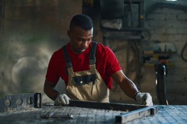 Afrikalı Amerikalı işçi atölyede metal çerçeve yapıyor.