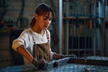 Atölyede metal detaylarıyla çalışan kadın işçi