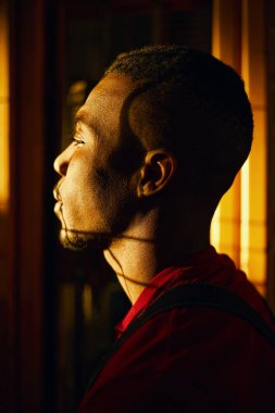 Fabrikada karanlıkta duran el işçisinin yan görüntüsü