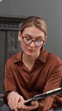 Stajyerin kadın meslektaşıyla ofisindeki belgeler hakkında konuştuğu dikey çekim.