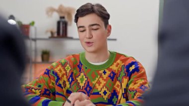 Z jenerasyonundaki beyaz adamın iş görüşmesinde masada oturan iki İK yöneticisiyle orta boy görüntüsü.