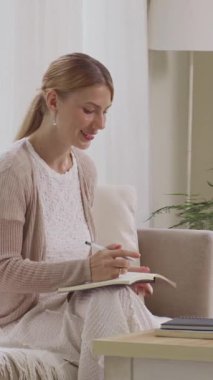 Kafkasyalı kadın çalışanın ev ofisinde çalışırken videoya çekilen dikey görüntüsü.