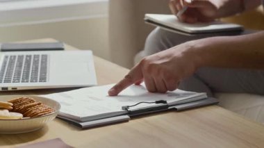 Evde dizüstü bilgisayarın önünde çalışırken iş planı yapan isimsiz bir erkek girişimcinin görüntüsü.