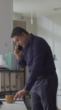 Ofiste çalışırken orta yaşlı bir adamın cep telefonundan arama görüntüsü.