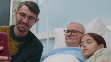 Hasta büyükbaba, torun ve babanın klinikteki cep telefonundan konuşmalarının el kamerası görüntüleri.