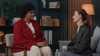 Orta ölçekli beyaz kadın müşterinin Afrikalı Amerikalı psikologlara teşekkür etmesi.