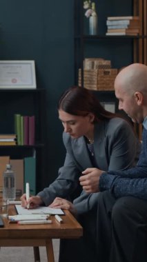 Beyaz çiftin, aile terapisi sırasında çizim egzersizi yaparken dikey çekimleri.